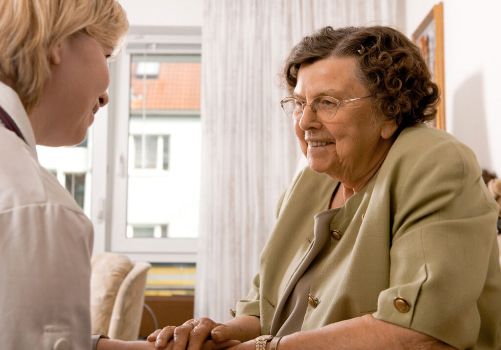 Hospice nurse talking with elderly woman